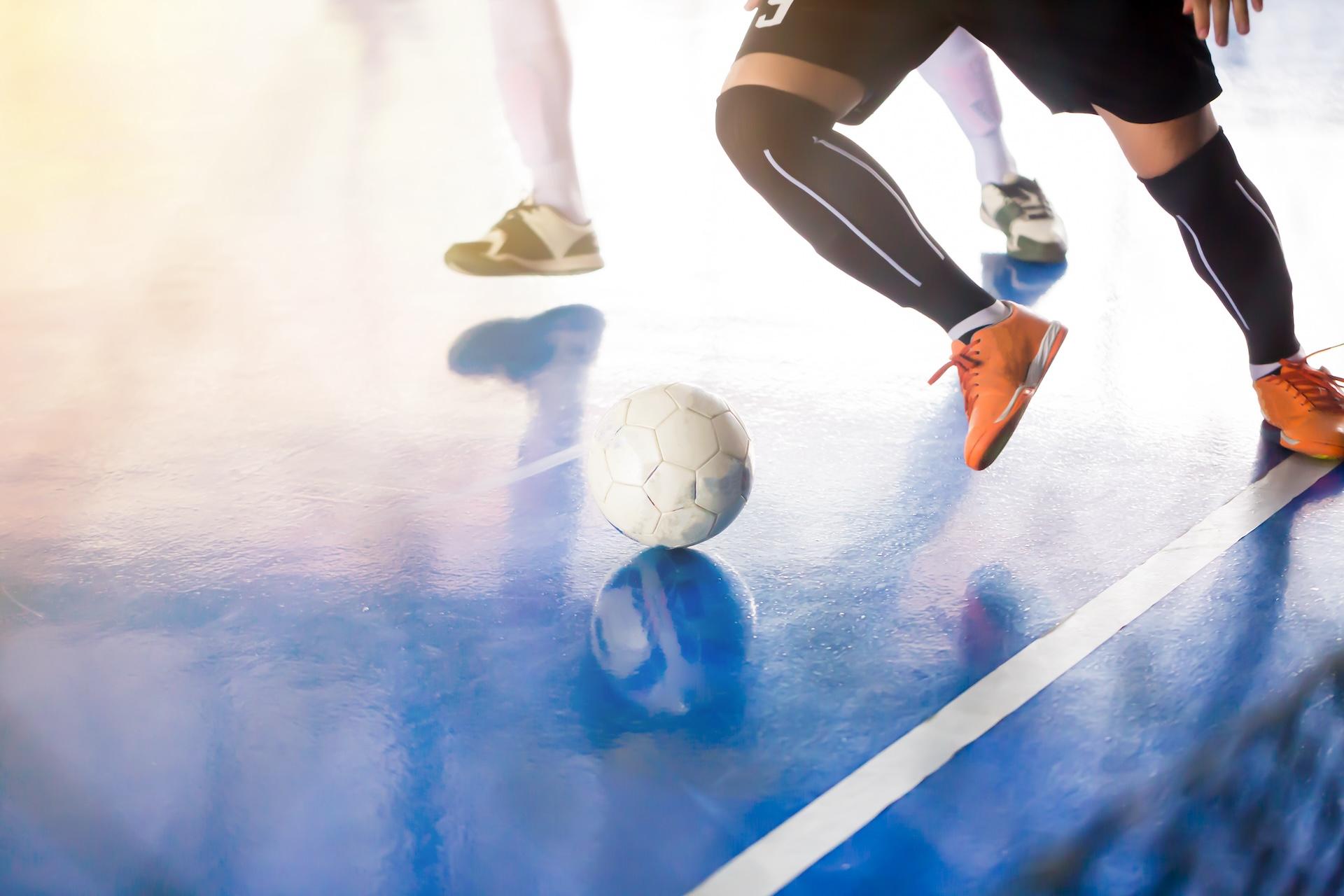 Close up of ball and legs of two futsal players in movement